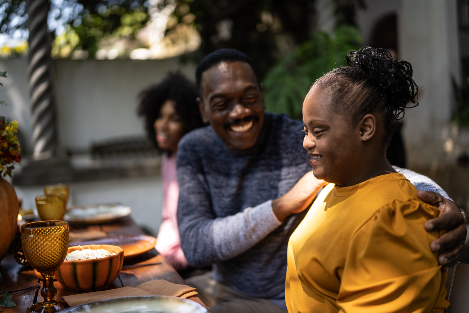 Father embracing special needs daughter on the table at home