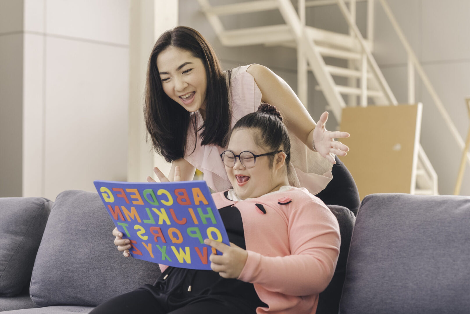 young girl with autism is practicing fun playing with toys at home with his mother. Autistic young students are learning with teachers happily.